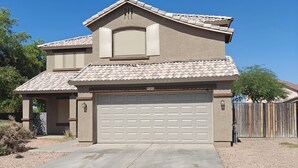 A two-story house with a garage, a covered driveway, and a fenced backyard. - La Rosa Phoenix (Phoenix)