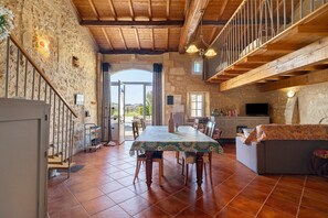 Un interior rústico con comedor, sofá y cocina.
