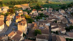 Un pueblo con calles estrechas, edificios históricos y vistas al campo circundante.