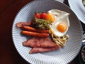 A plate with eggs, bacon, sausages, and vegetables. - Relaxing 1-bedroom resort with AC in peaceful Preah Sihanouk #3 (Preah Sihanouk,)