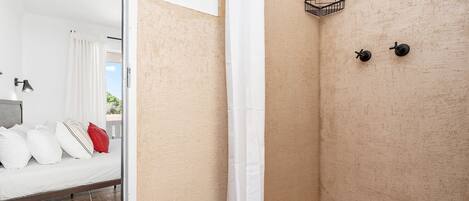 Un baño moderno con zona de ducha, inodoro y lavabo.