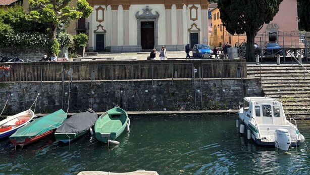 A historic building with a bell tower, a waterfront, and boats docked. - The Lemon House Lemon House at the Lake. Elegant apartment with garden (Bellagio)