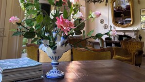 A room with a wooden table, a vase with flowers, a chandelier, and a mirror on the wall. - The Lemon House Lemon House at the Lake. Elegant apartment with garden (Bellagio)