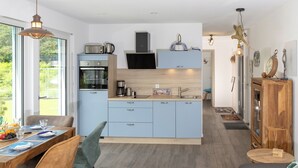 Een moderne keuken met een inbouwoven, een koffiezetapparaat en een houten aanrecht.