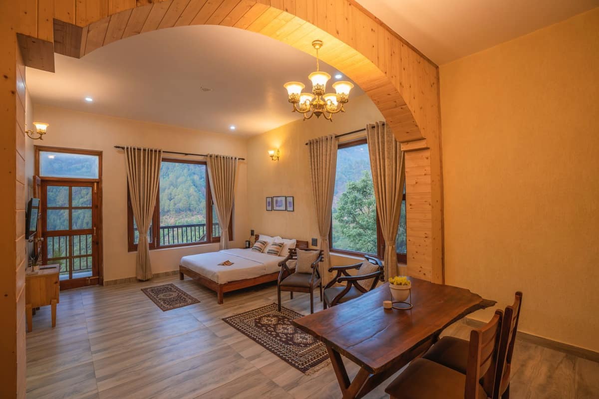 Un dormitorio acogedor con cama, una mesa de comedor de madera y una araña.