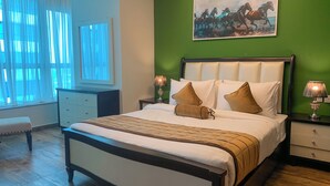 A bedroom with a large bed, green walls, a painting of horses, and a window with sheer curtains.