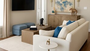 Una sala de estar moderna con un sofá, una mesa de centro, un televisor y un cuadro en la pared.