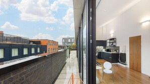 A modern apartment with a balcony, a kitchen, and a dining area. - Stylish Hoxton Duplex – Perfect for Couples & Small Groups (London)