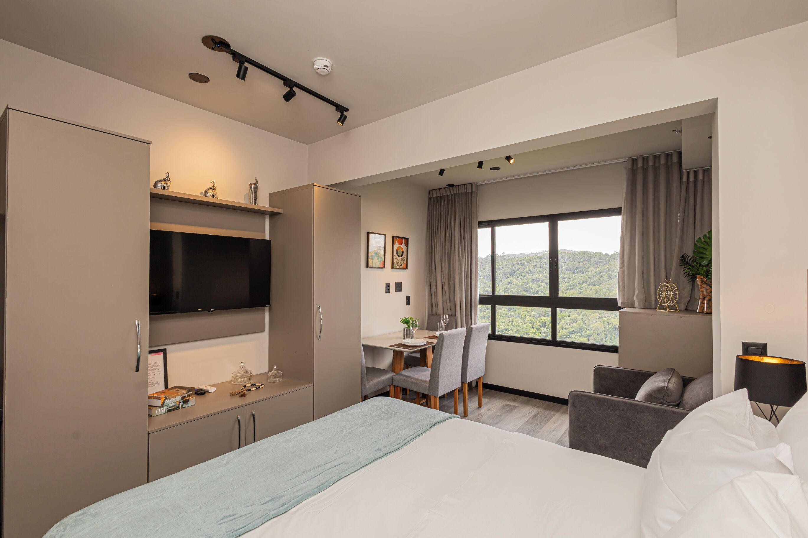Una habitación de hotel moderna con una cama, un escritorio y un televisor.