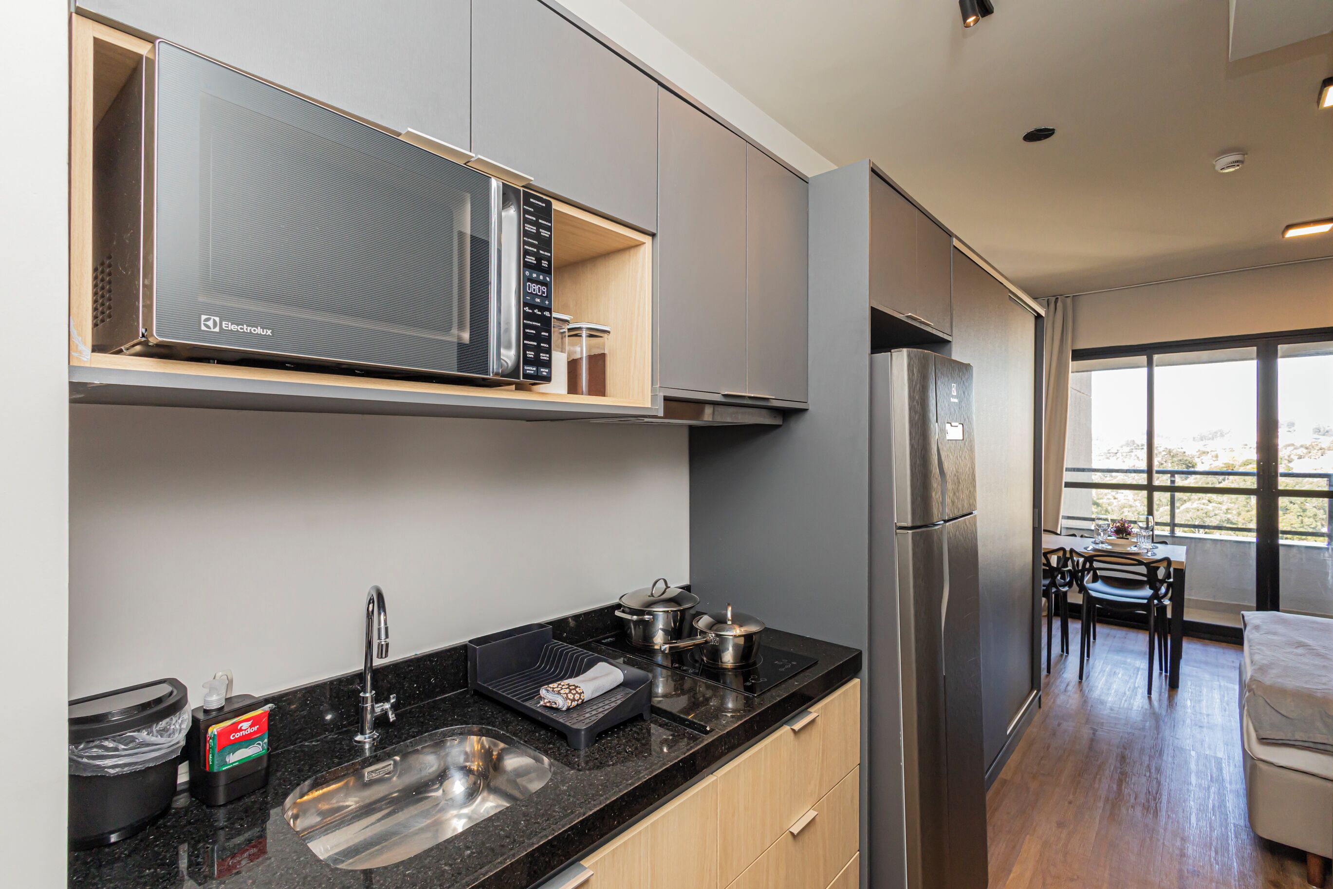 Una cocina moderna con microondas integrado, electrodomésticos de acero inoxidable y un comedor con vistas.