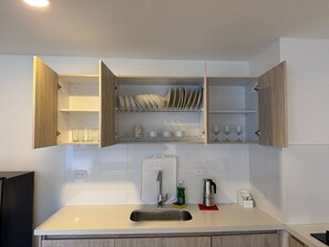 Een keuken met een ingebouwd spoelgedeelte, houten kastjes en een afwasschaal boven het aanrecht.