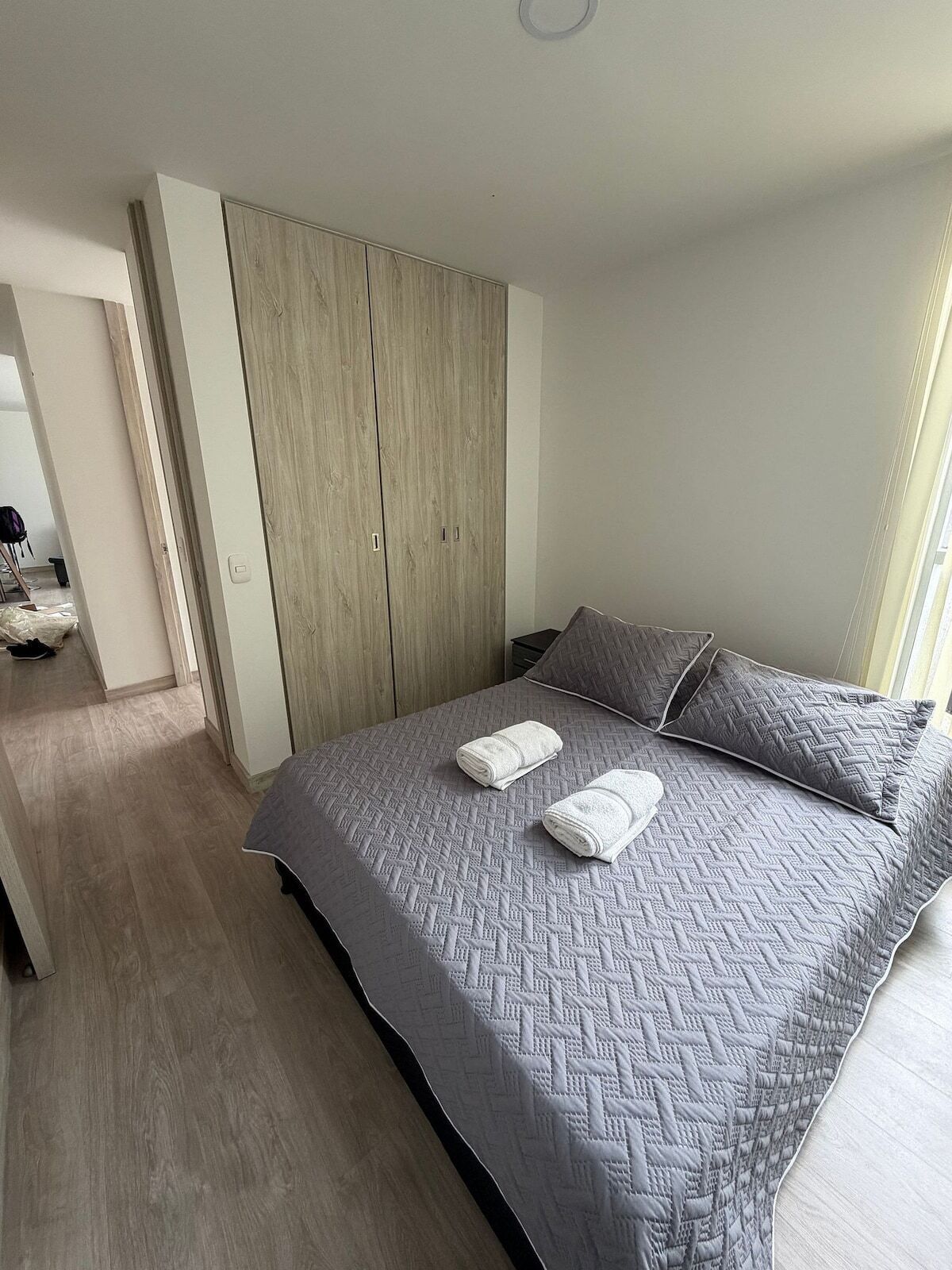 Une chambre à coucher avec un lit, une armoire et une salle de bain à l’arrière-plan.