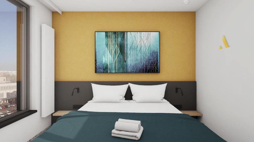 Een moderne hotelkamer met een groot bed, uitzicht over de stad en een modern abstract schilderij aan de muur.