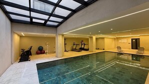 Une vaste piscine intérieure dotée d’équipements de musculation et de coins salon.