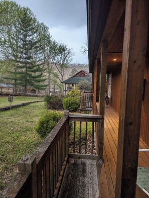 Eine Holterrasse mit Geländer, die zu einem Gebäude mit einer Veranda führt.