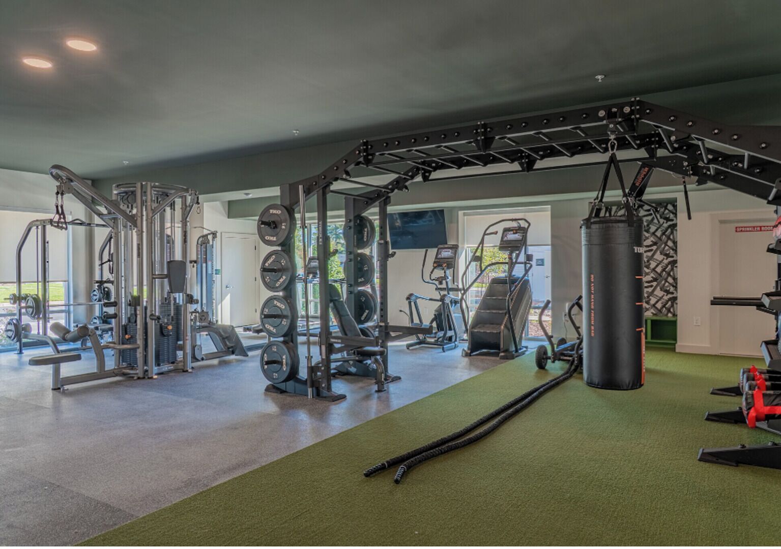 A gym with weightlifting equipment, treadmills, and a punching bag.