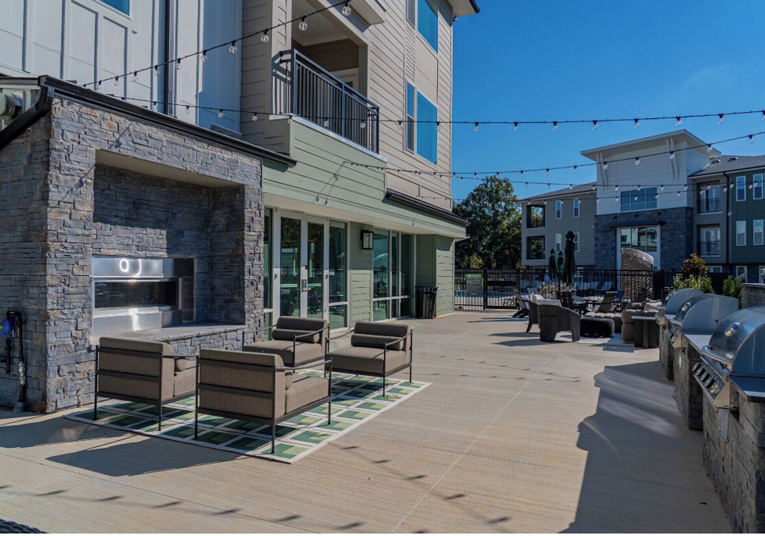 An outdoor patio area with stone walls, a grill station, and outdoor seating.