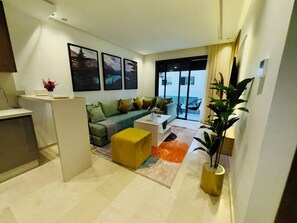 Ein modernes Wohnzimmer mit einer Couch, einem Couchtisch und Blick ins Freie.