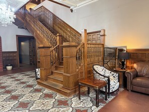 Un magnifique escalier avec des rampes en bois et une moquette à motifs.