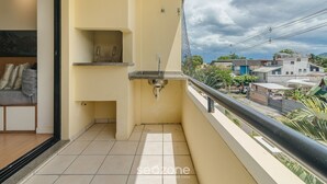 A balcony with a sink, a small shelf, and a view of the neighborhood. - Apt w/ Barbecue 650m From the Lagoon Ruh0109 (Florianópolis)