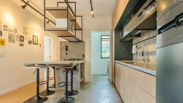 A modern kitchen with a central island, bar stools, and a built-in oven. - Apt w/ Barbecue 650m From the Lagoon Ruh0109 (Florianópolis)