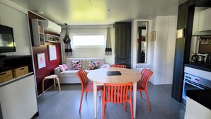Eine moderne Küche mit Essbereich, einer Couch und einem Fernseher.