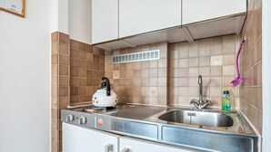 Une cuisine équipée d’une cuisinière, d’un évier et d’une hotte aspirante.