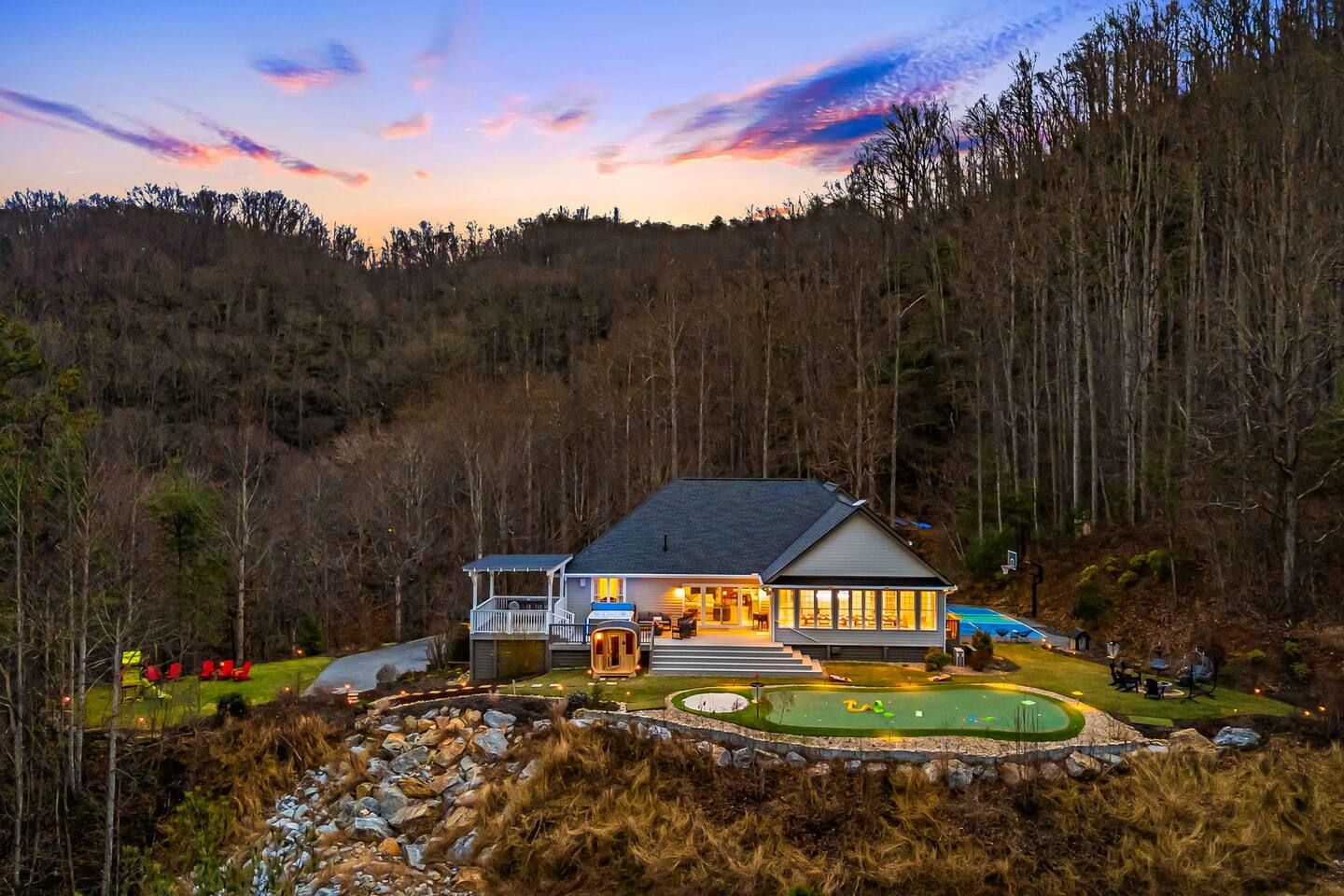 A two-story house with a porch, a swimming pool, and a well-maintained lawn.