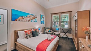 Ein Schlafzimmer mit einem Bett, einem Sessel, einem Tisch und einem Schrank.