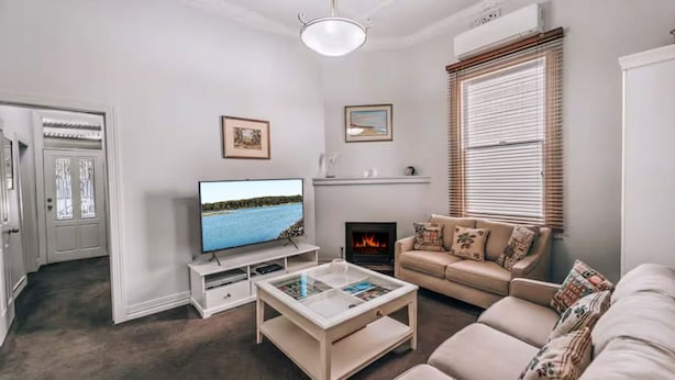 Ein Wohnzimmer mit Fernseher, Kamin, Sofa und Couchtisch.