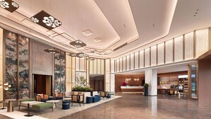 Un hall d’entrée spacieux, doté d’espaces aménagés pour s’asseoir, d’un comptoir de réception et d’un design de plafond moderne.