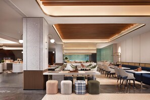 Un restaurante moderno con zona de comedor central, cabinas y barra.