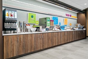 A breakfast bar with a variety of food and drink options, including yogurt, oatmeal, pancakes, and eggs. - Tru By Hilton Hagerstown (Hagerstown)