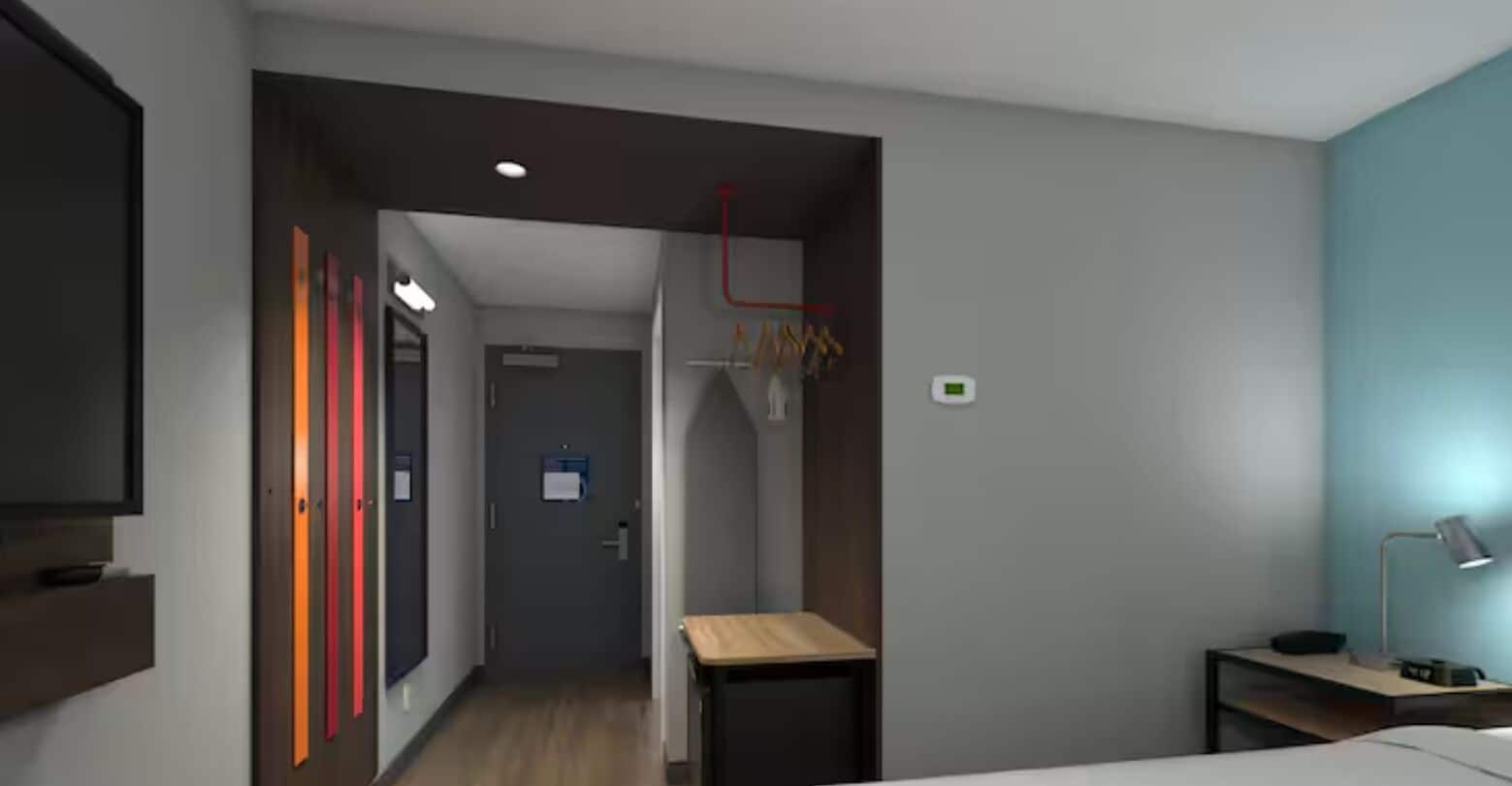 Une chambre d’hôtel moderne équipée d’un lit, d’un bureau et d’une armoire.