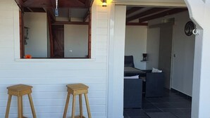 Une pièce avec un banc en bois, un miroir et une porte donnant sur une salle de bain.