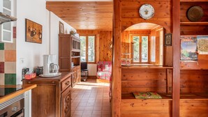 A wooden interior with a kitchen, dining area, and a cozy seating space.