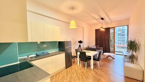 Une cuisine moderne équipée d’un évier, d’une cuisinière et d’un coin repas avec une table et des chaises.