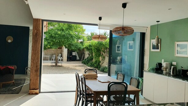 Een modern interieur met een eetgedeelte, keuken en uitzicht op de omgeving.