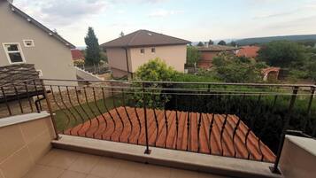 A balcony with a tiled floor and a metal railing.