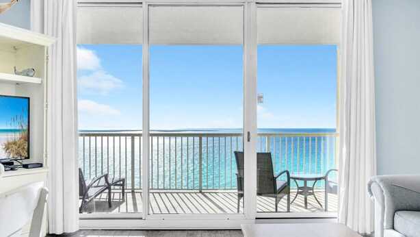 A balcony with a view of the ocean, a white desk with a computer, and a grey sofa. - Majestic Beach Towers 1-1314 (Panama City Beach)