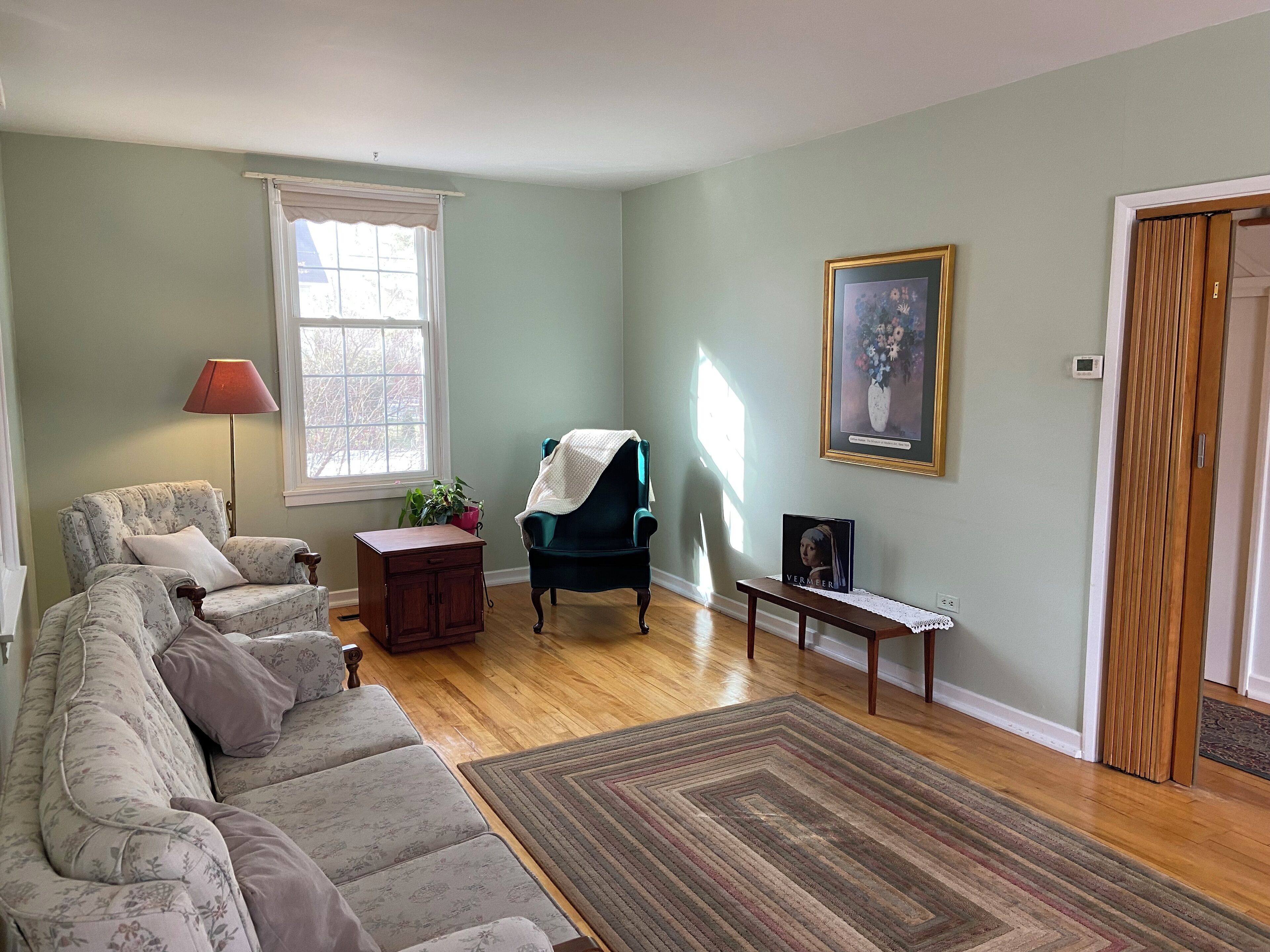 A living room with a sofa, a chair, a small table, and a rug.