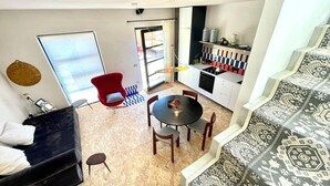 Een knus woongedeelte met eethoek, kitchenette en een bank.