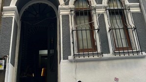 En bygning med flere etager i klassisk arkitektur, med dekorative vinduesrammer og en balkon.