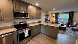 A modern kitchen with stainless steel appliances, granite countertops, and a view to the living area. - Quaint 2-bedroom apartment Historic downtown Florence (Florence)
