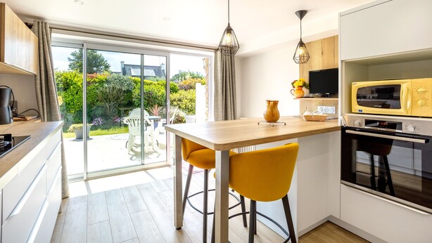 Una cocina moderna con comedor, un ventanal y vistas al jardín.