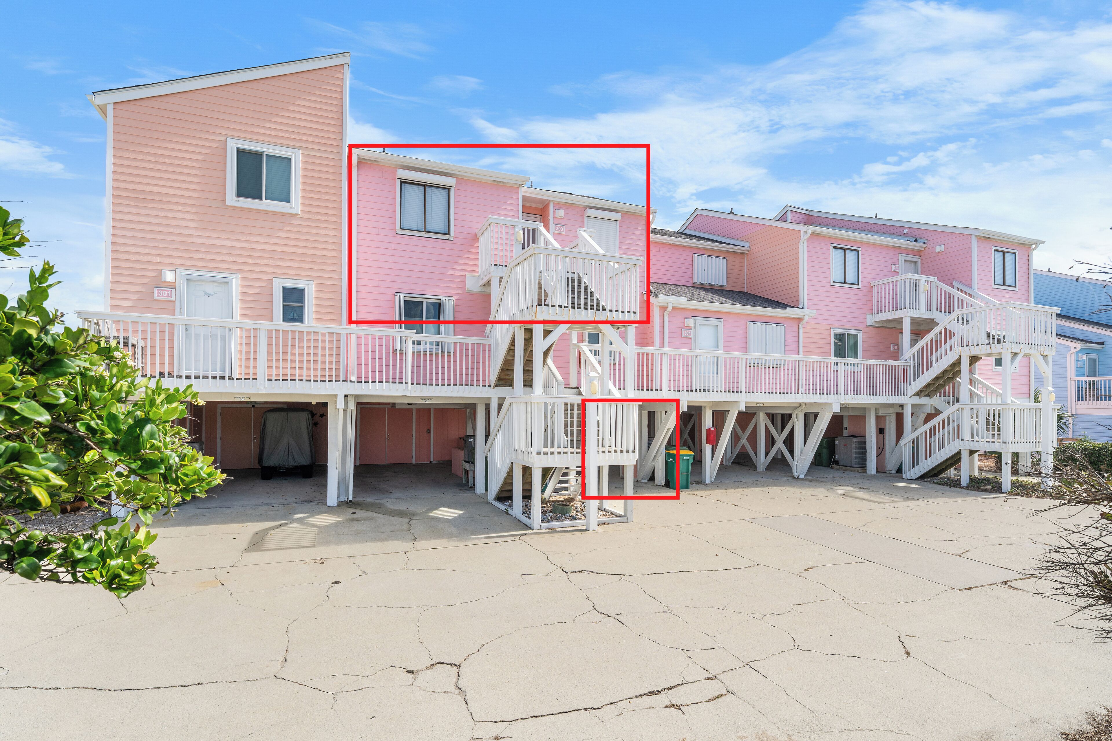 A pink building with multiple balconies and a staircase.