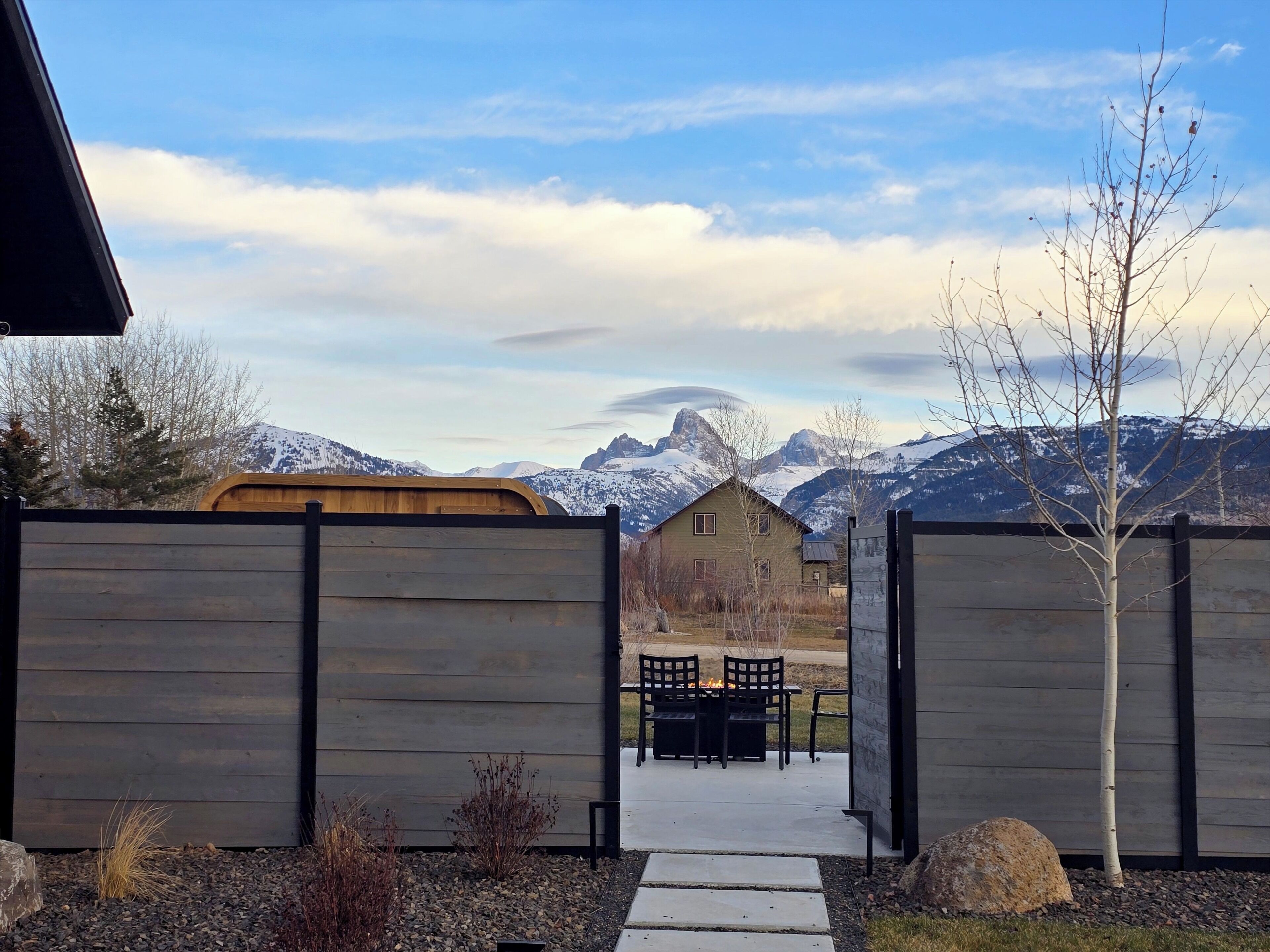 Private patio with fire pit, fenced yard, and sweeping mountain views