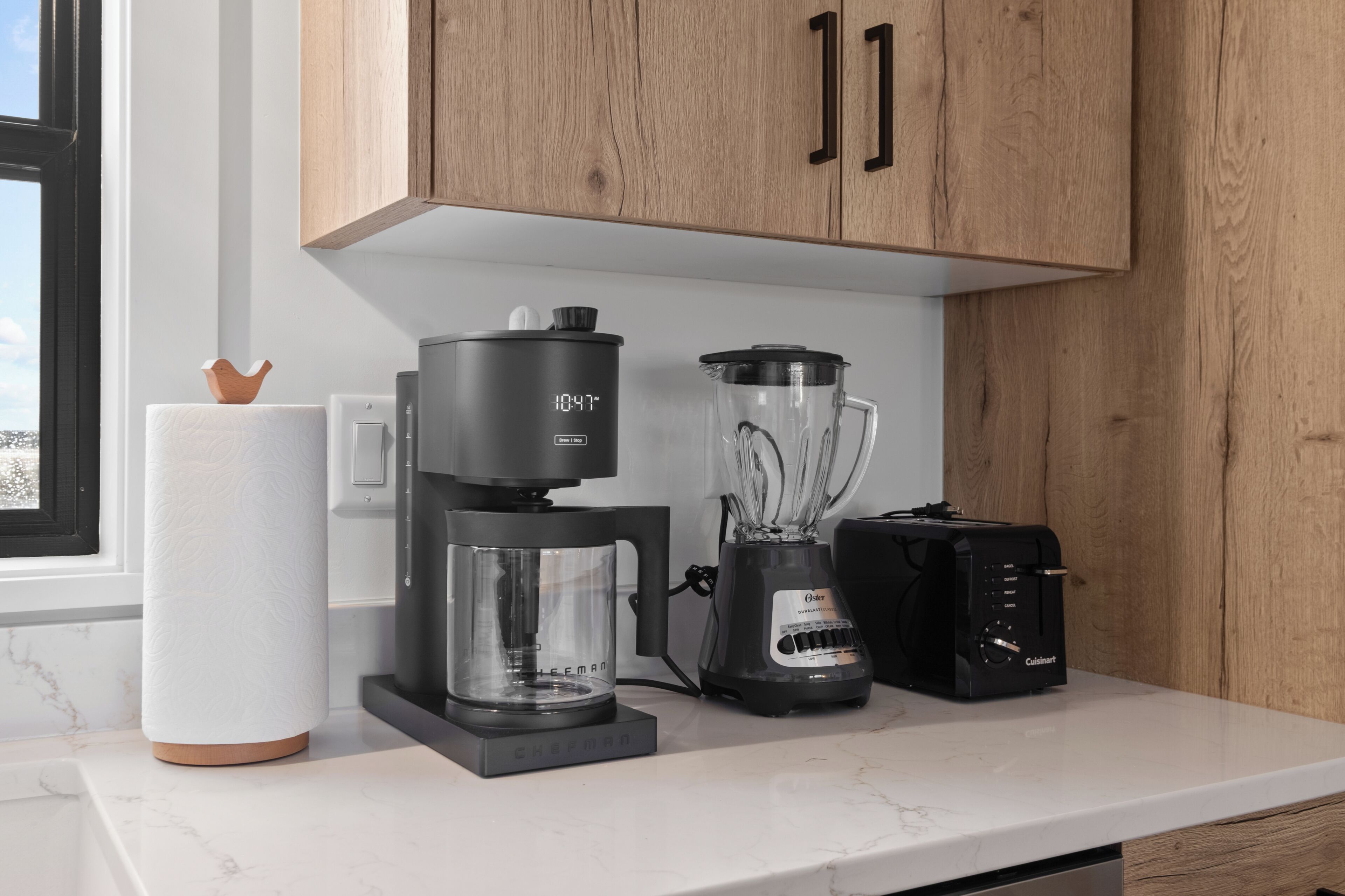 A kitchen with a coffee maker, blender, and toaster on the counter.