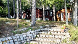 A rustic cabin with a stone staircase leading to a wooden deck. - Ely Lakeside Cabin: The Perfect Northwoods Retreat (Ely)