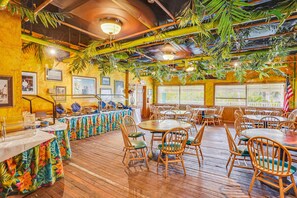A restaurant with wooden floors, round tables, and chairs. - Harbourside 8816 (Indian Rocks Beach)